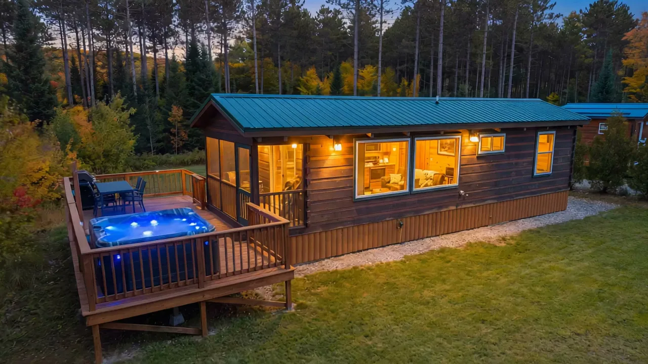 The Modern Tiny Home at dusk, its hot tub lit on the deck