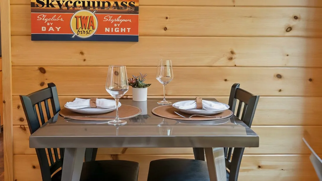 A table set for two under a vintage airline poster in The Aviator
