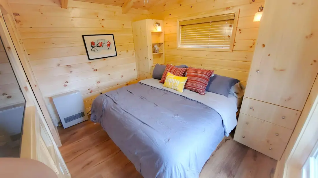 The main bedroom in an earlier listing photo, with the hockey print on the wall beside the bed