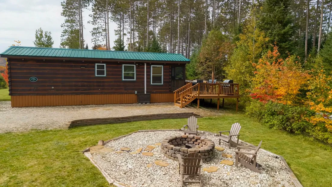 The big stone fire pit and its chairs in front of The Modern Tiny Home