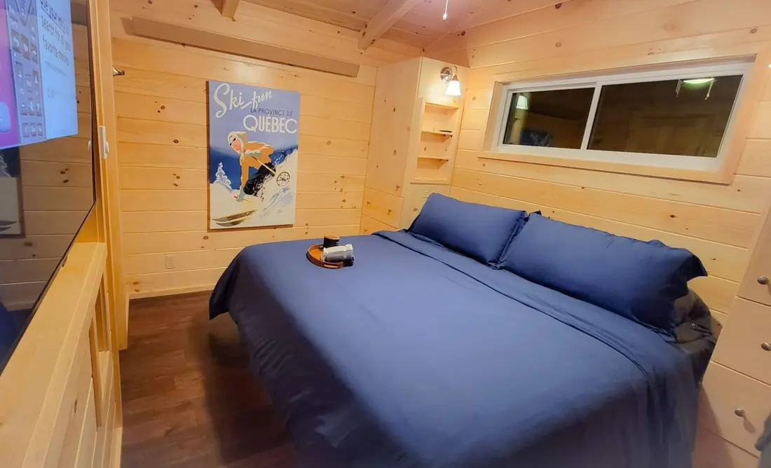 The vintage Ski-fun, La Province de Québec poster beside the bed in The Modern Pine's main bedroom