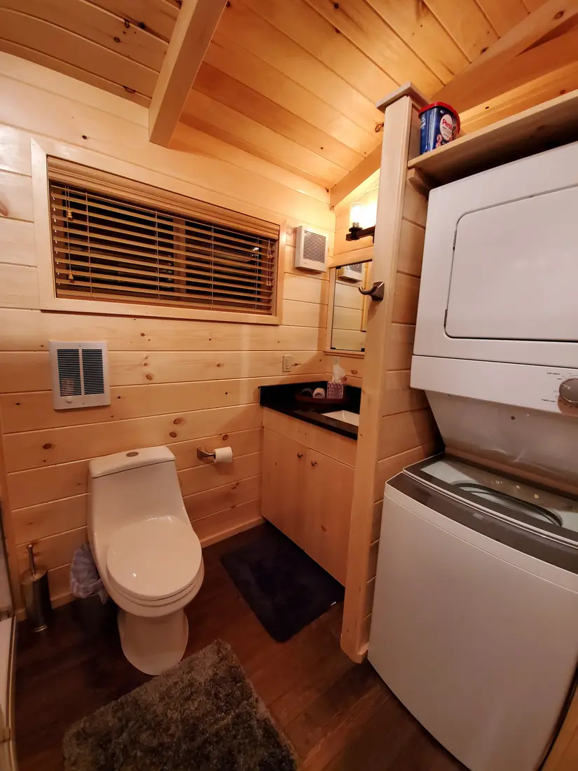 The stacked washer and dryer in The Modern Pine's bathroom